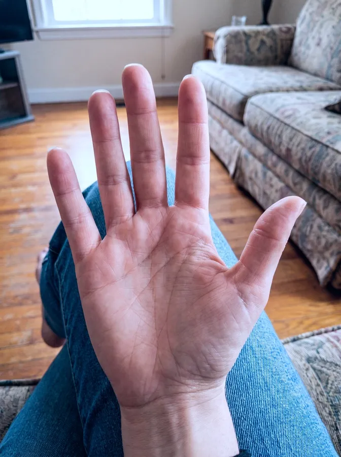 An open palm held out in a living room